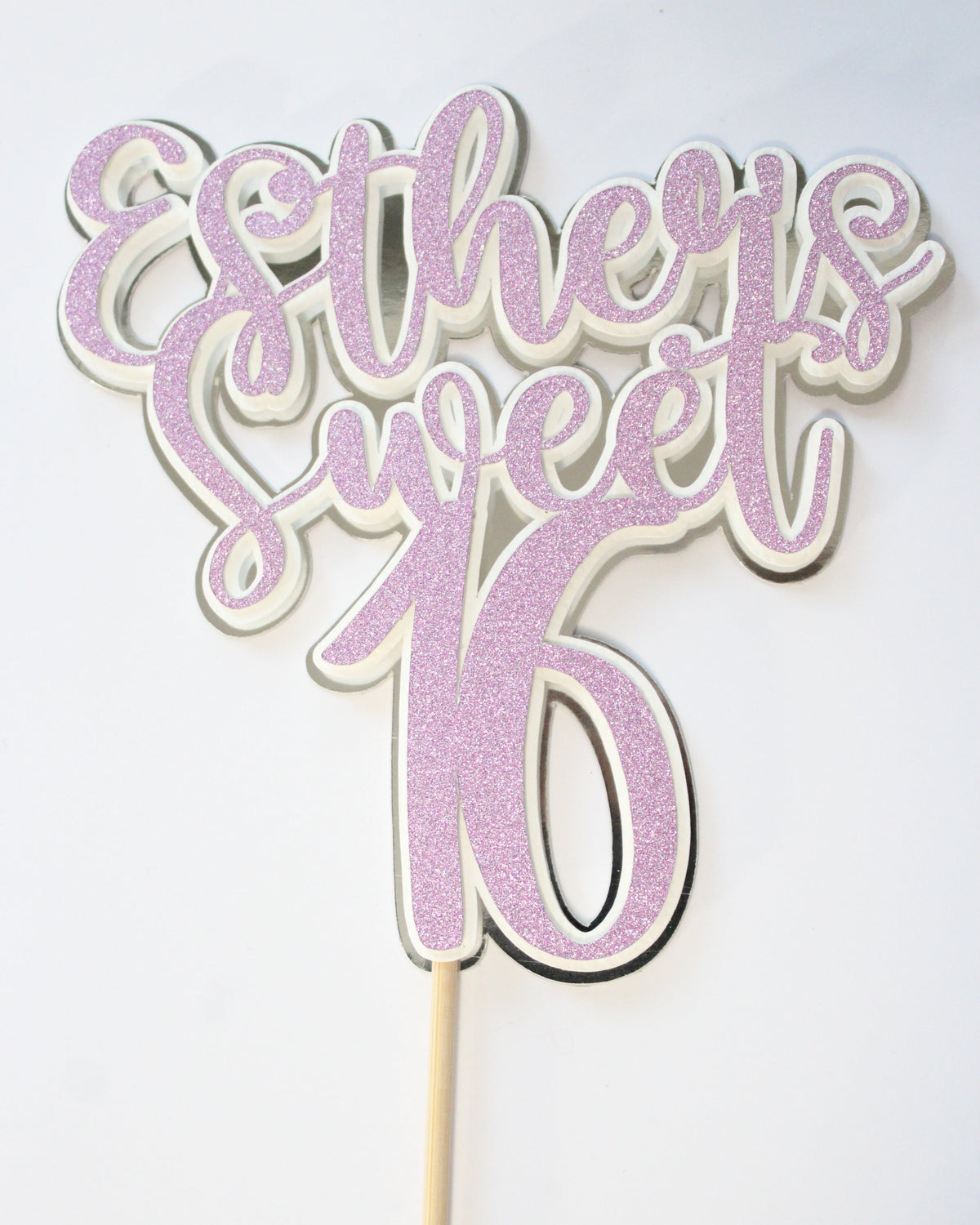 Decorative cake topper with pink glittery design on a white background