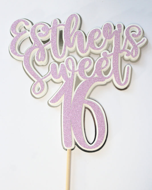 Decorative cake topper with pink glittery design on a white background