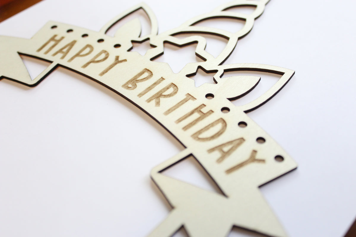 Unicorn themed Wooden birthday cake topper with 'Happy Birthday' text on a white background